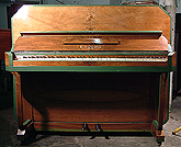 An art cased Squire upright piano with an art-deco style walnut case with painted detail. 