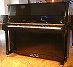 A brand new Fenner upright piano with a black case and polyester finish