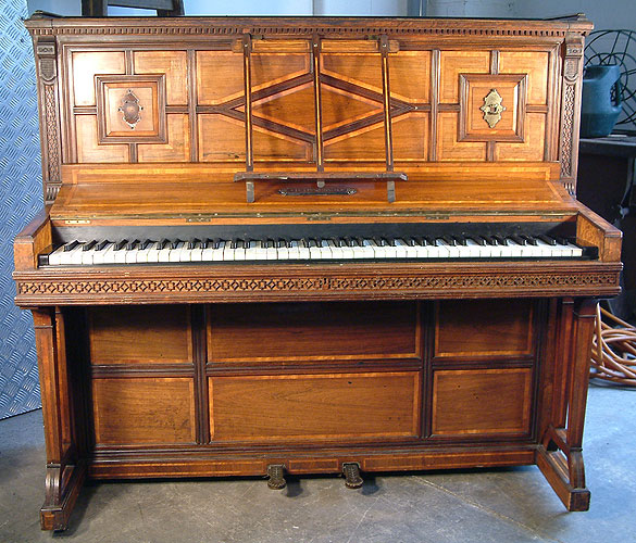 An 1875, Hopkinson upright piano with a polished, rosewood case, inlaid with a variety of woods and carved detail.