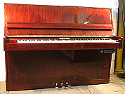 A Schaefer upright piano with a mahogany case and polyester finish. Fitted with a Piano Disk GT- QuietTime system allowing silent play via headphones.