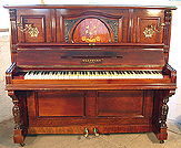 A Waldberg upright piano with a polished, rosewood case and inlaid detail in an art nouveau design. 