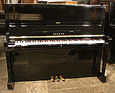 A Yamaha U1 upright piano with a black case and polyester finish. 