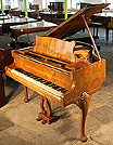 A Strohbech baby grand piano with a polished, walnut case. 