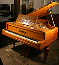 An antique Collard & Collard grand piano with a polished, satinwood case.