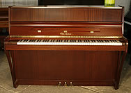 A Gaveau upright piano with a polished, mahogany case.