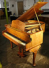 A Monington and Weston baby grand piano with a walnut case. Ideal for a smaller space.