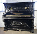 An August Forster upright piano with an ornately carved  black case
