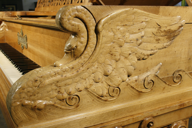 Depicting themes from the Ring Cycle, carved swans sit on each piano cheek. Each sits on the crest of a wave with wings outstretched