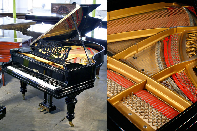 An antique, Berdux  grand piano with a polished, black case and turned legs