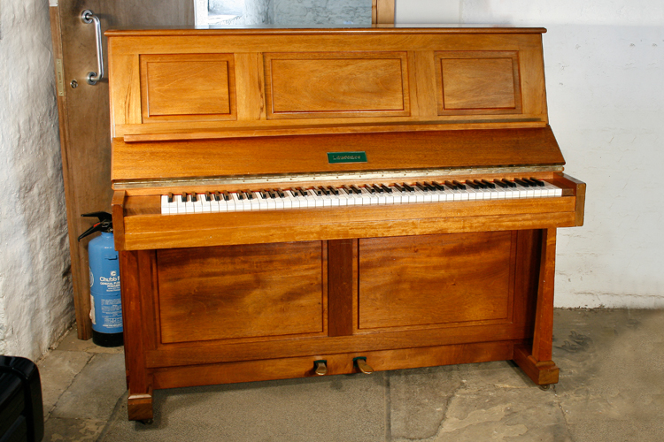 A Laurence upright piano with a solid mahogany case