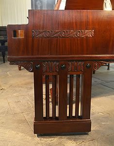 The gate legs of this Ibach grand piano have three rectangular upright posts divided by two rods. At the pediment of the leg is carved stylised detail