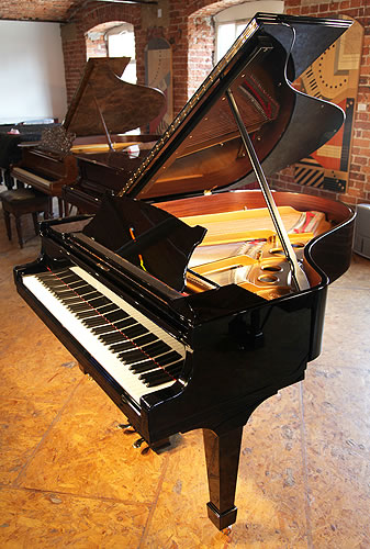 A 1926, Steinway Model O grand piano with a black case and spade legs