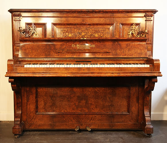 An antique, 1894 Steinweg Nachf upright piano with a burr walnut case and inlaid panel