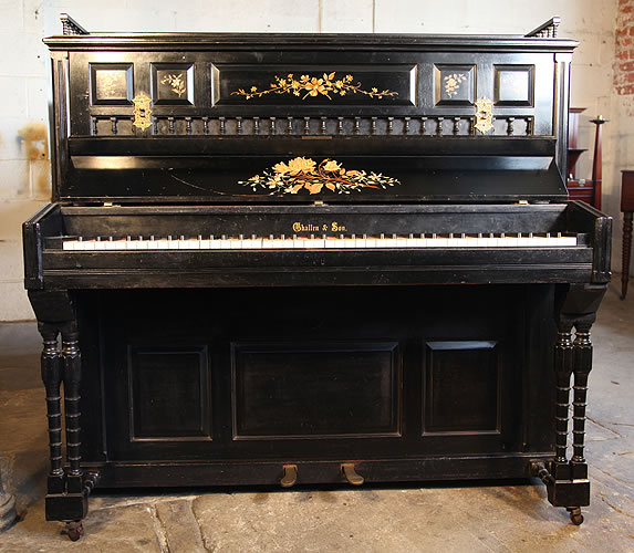 An 1884, Challen upright piano with a black case. Cabinet features spindles and floral decor on panels.