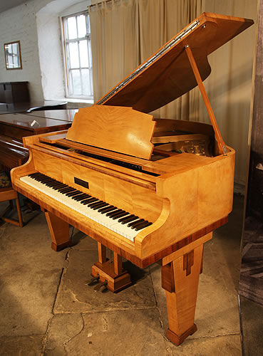 A 1935, Art Deco style, Monington and Weston baby grand piano with a satinwood case and rosewood accents. Piano Legs and music desk feature strong geometric styling