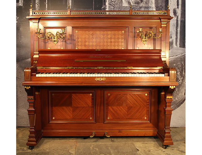 A 1926, Schiedmayer 7a upright piano with an Empire style, mahogany case. Cabinet features marquetry inlaid panels and bronze decoration