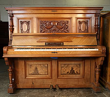 Tredt upright  piano with a walnut case and carved high-relief panels featuring swags and flowers