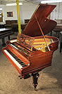 An antique, Bechstein Model A grand piano with a polished, rosewood case and turned legs.