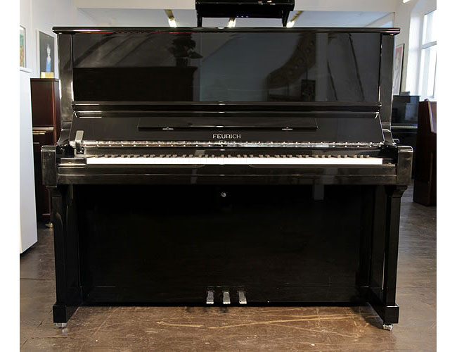 A Brand New Feurich Model 133 Concert upright piano with a black case and chrome fittings