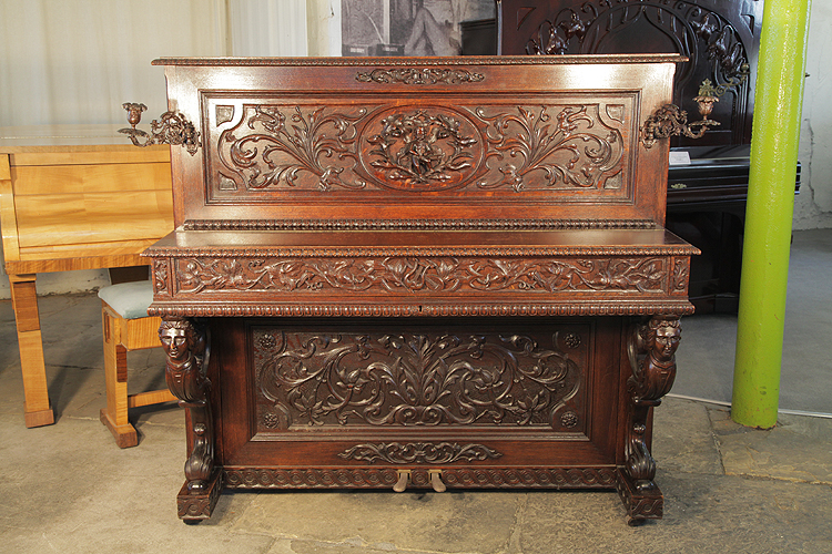 A Mand Upright Piano with a carved, Neoclassical Style Oak Case
