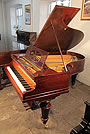 A restored, Bechstein Model A grand piano with a polished, rosewood case and turned legs.