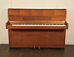 A 1987, Kawai CX-4S upright piano with a polished, mahogany case and brass fittings.