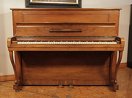 A 1952, Steinway Model Z upright piano with a mirrored, walnut case and cabriole legs. 