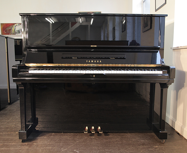 A 1973, Yamaha U3 upright piano with a black case and polyester finish