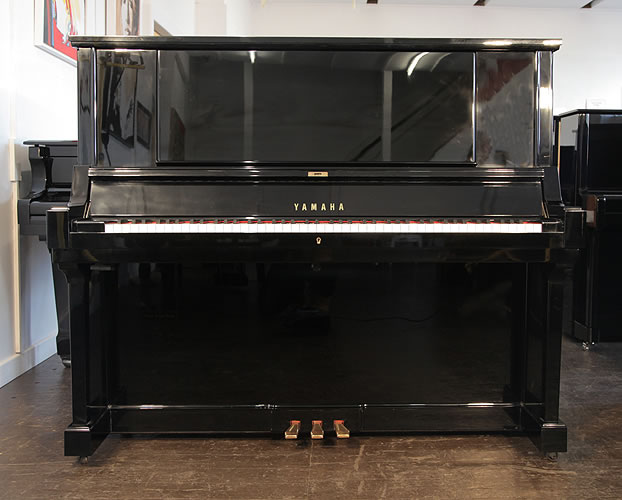 A hand-built, 1980, Yamaha YUA upright piano with a black case and brass fittings