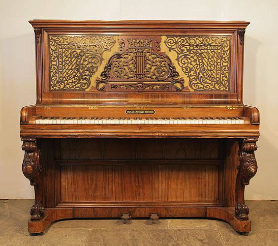 Kirkman upright piano with a rosewood case and ornate fretwork front panel