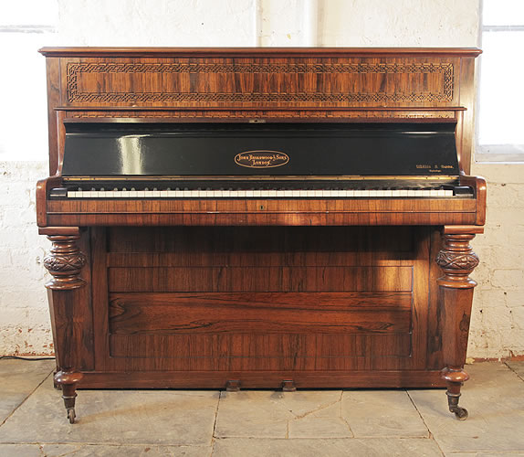Broadwood upright piano with a rosewood case, fretwork detail and carved, facetted legs