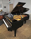 Piano for sale. A 1971, Yamaha C7 grand piano for sale with a black case and spade legs.