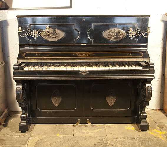  博得（Bord）立式古董钢琴，产于1897年，黑色外壳，钢琴外壳有精美的浮雕，人形天使演奏乐器的团，精美黄铜烛台弯曲琴腿，博得钢琴于1934年被普莱耶（Pleyel）钢琴公司所收购