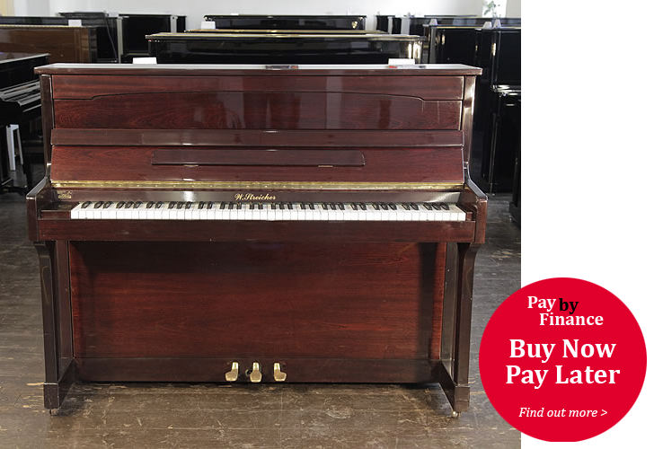 A Streicher upright piano with a mahogany case .