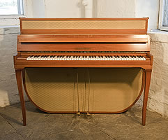 A 1955, Mid Century Modern style, Grotrian-Steinweg model 110 upright piano with a walnut case and fabric panels. Piano has an eighty-five note keyboard and two pedals. 