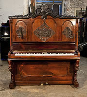 Antique, Brandeis upright piano for sale with a rosewood case and reverse scroll, claw foot legs. Front panel features ornately carved plaques with heads of Beethoven and Mozart. Carved pediment features a central harp surrounded by scrolling acanthus and laurel. 