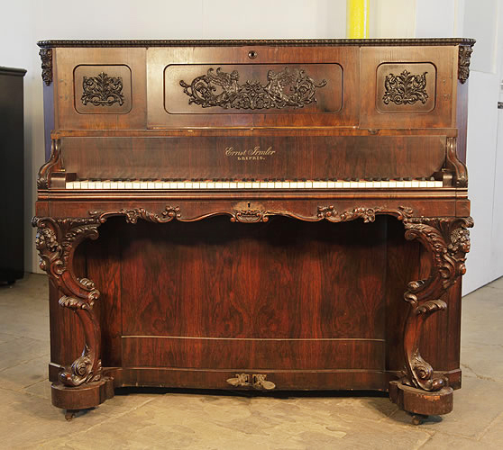 Ernst Irmler upright piano for sale with an ornately carved, rosewood case, Cabinet features carved panels of winged females with scrolling foliage and reverse scroll legs with carved femal heads.