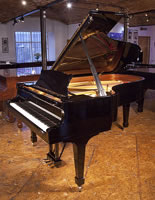A 2013, Steinway Model B grand piano for sale with a black case and spade legs. Piano has an eighty-eight note keyboard and a three-pedal lyre.