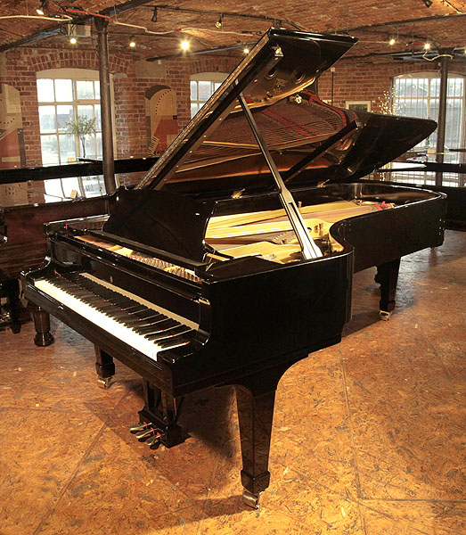 A 1955, Steinway & Sons Model D concert grand piano with a black case and spade legs. Piano has an eighty-eight note keyboard and a three-pedal lyre.