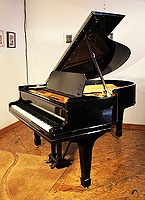 A rebuilt, 1909, Steinway Model O grand piano with a black case and spade legs.