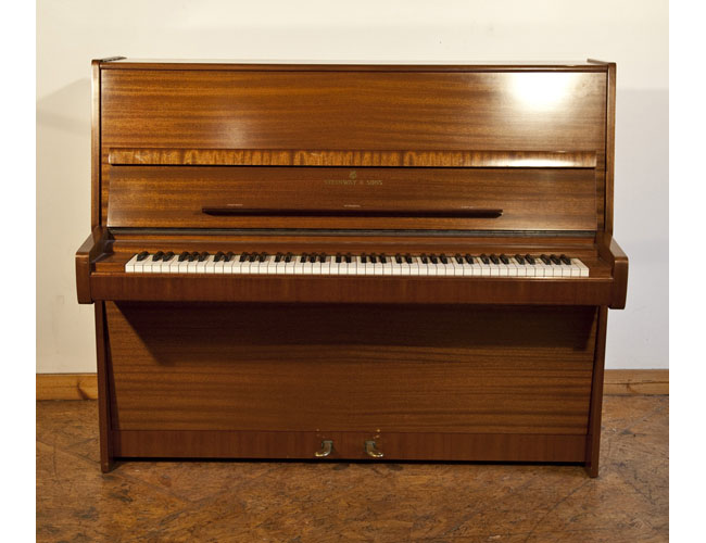 A 1975, Steinway Model V upright piano with a polished, mahogany case with brass fittings. Piano has an eighty-eight note keyboard and two pedals.