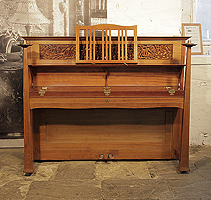 An 1898, Arts and Crafts style, Bechstein upright piano with a walnut case and ornate fretwork panel cut in a sinuous floral design. Cabinet features sizeable, brass hinges and large sculptural candlesticks. Designed by Walter Cave