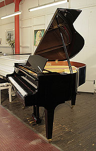 A 2013, Yamaha GB1 baby grand piano for sale with a black case and square, tapered legs. Piano has an eighty-eight note keyboard and a three-pedal lyre.