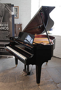 A 2015, Kawai GM-10K baby grand piano for sale with a black case and square, tapered legs. Piano has an eighty-eight note keyboard and a three-pedal lyre.