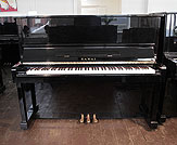 Piano for sale. A 1985, Kawai NS-10 upright piano with a black case and polyester finish. Piano has an eighty-eight note keyboard and three pedals.  