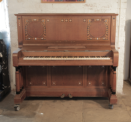 Kohl upright piano for sale with a walnut case and three turned, column legs. Entire cabinet inlaid with contrasting ebony and mother of pearl in a stylised floral design  