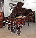 Rebuilt, 1874, Steinway & Sons Model D concert grand piano for sale with a rosewood case, filigree music desk and ornately carved, reverse scroll legs. Piano has an eighty-eight note keyboard and a two-pedal lyre. 