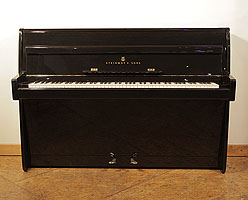 A 1961, Steinway Model F upright piano with a black case and brass fittings