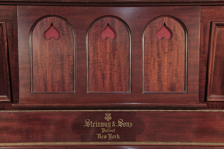 Steinway music desk in a three arch design with cut-out inverted hearts backed with red felt .