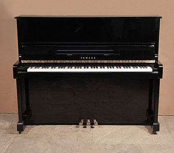 A 1988, Yamaha MC10Bl upright piano with a black case and polyester finish.. Piano has an eighty-eight note keyboard and three pedals.     